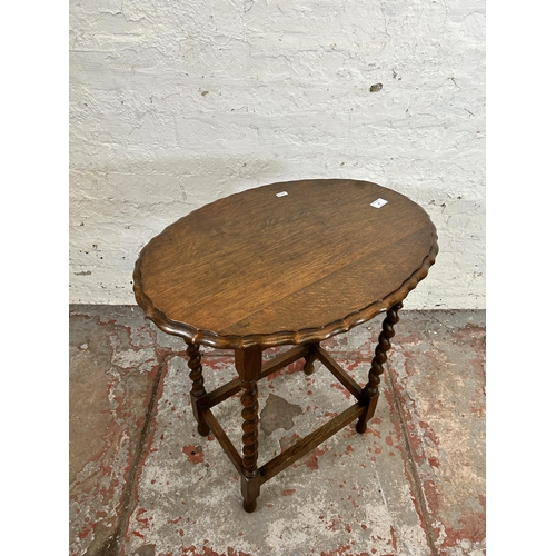 60 - An oak pie crust edge oval side table on barley twist supports - approx. 67cm high x 44cm wide x 61c... 