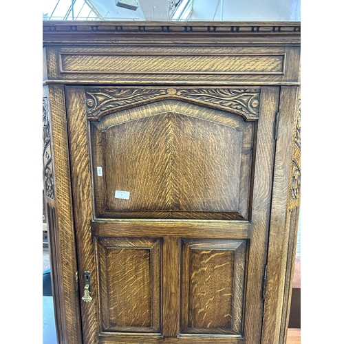 7 - A carved oak single door wardrobe with fitted interior - approx. 184cm high x 79cm wide 41cm deep