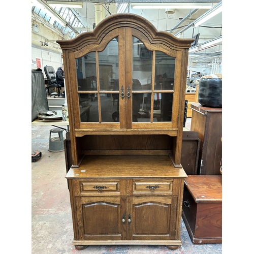 131 - An oak dresser with two upper glazed doors, two drawers and two lower cupboard doors - approx. 205cm... 