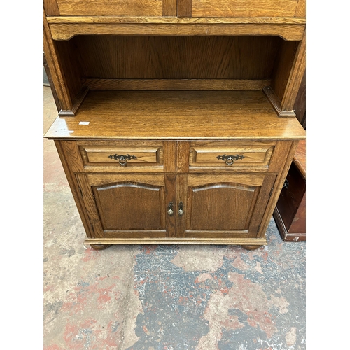 131 - An oak dresser with two upper glazed doors, two drawers and two lower cupboard doors - approx. 205cm... 