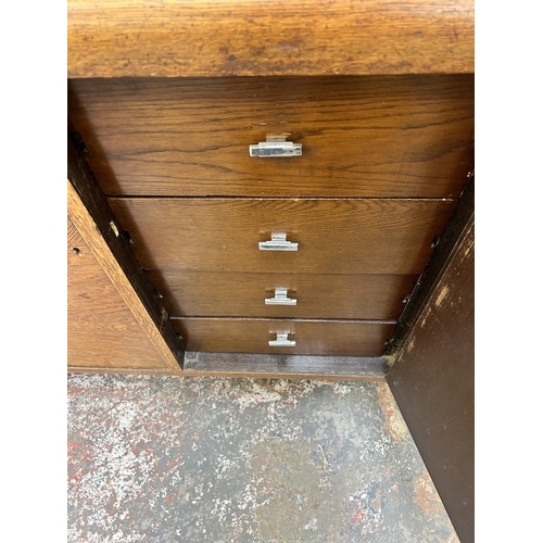 135A - An Art Deco oak sideboard with three cupboard doors, four internal drawers and baluster supports - a... 