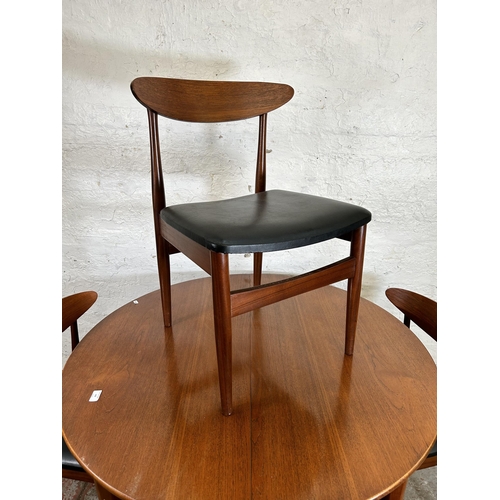 149 - A 1960s teak circular extending dining table and four teak and black vinyl dining chairs - table app... 