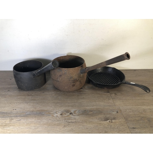 289 - Three pieces of cast iron kitchenware, two saucepans and one frying pan