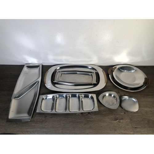 306 - Nine pieces of mid 20th century stainless steel kitchenware to include four teak handled trays etc.