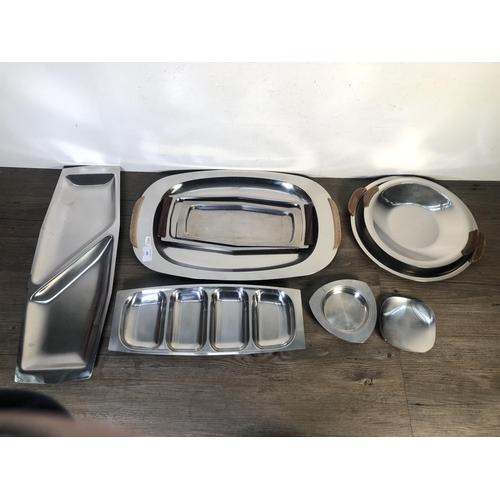 306 - Nine pieces of mid 20th century stainless steel kitchenware to include four teak handled trays etc.