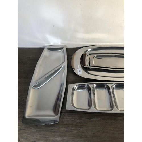 306 - Nine pieces of mid 20th century stainless steel kitchenware to include four teak handled trays etc.