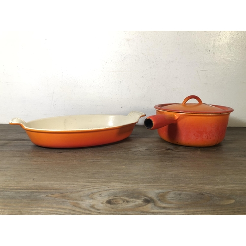 313 - Two pieces of orange enamel and cast iron kitchenware, one Le Creuset no.28 twin handled casserole d... 