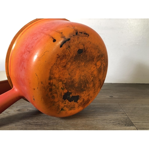 313 - Two pieces of orange enamel and cast iron kitchenware, one Le Creuset no.28 twin handled casserole d... 