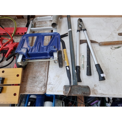 750 - A collection of items to include wooden handled and cast iron sledgehammer, folding workbench, hose ... 