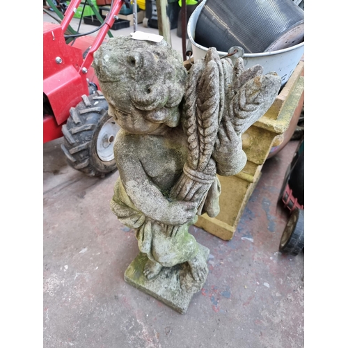 771 - A collection of planters and garden ornaments to include cast stone cherub holding wheatsheaf figure... 