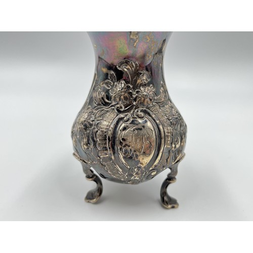 1168A - A George III John Muns hallmarked London silver repoussé tri footed milk jug, dated 1764 - approx. g... 