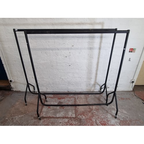 169A - Two black tubular metal clothes rails - largest approx. 158cm high x 182cm wide