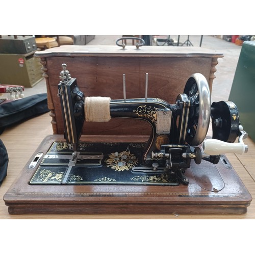 638 - A cased antique German hand-crank sewing machine