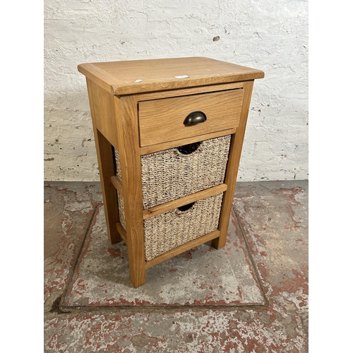 10 - A Wiltshire oak side table with single drawer and two wicker baskets