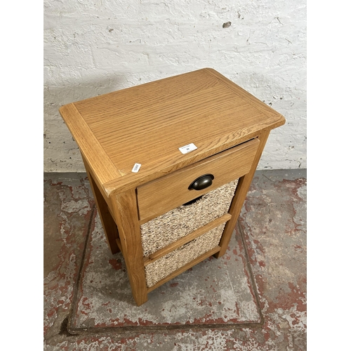 10 - A Wiltshire oak side table with single drawer and two wicker baskets