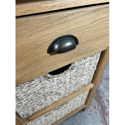 10 - A Wiltshire oak side table with single drawer and two wicker baskets