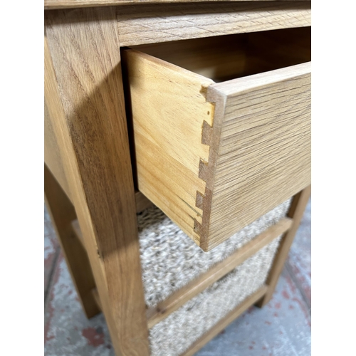 10 - A Wiltshire oak side table with single drawer and two wicker baskets