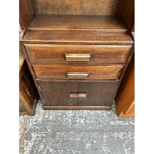 42 - An Art Deco oak bookcase cabinet with single shelf, two drawers and two cupboard doors - approx. 110... 