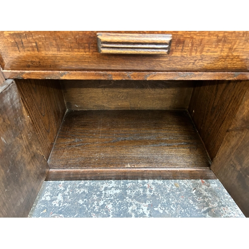 42 - An Art Deco oak bookcase cabinet with single shelf, two drawers and two cupboard doors - approx. 110... 