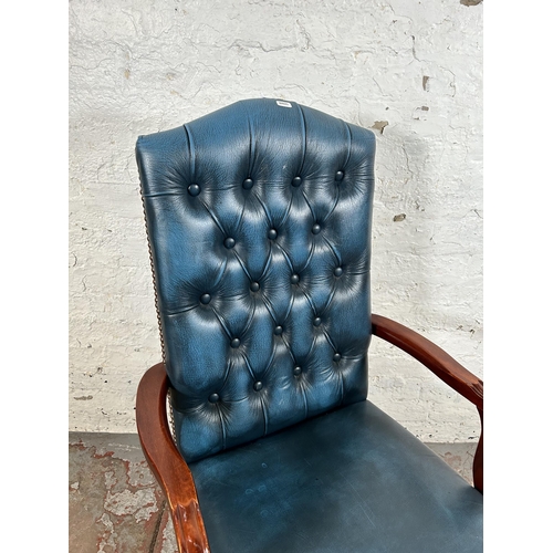 52 - A mahogany and blue leatherette Chesterfield office armchair