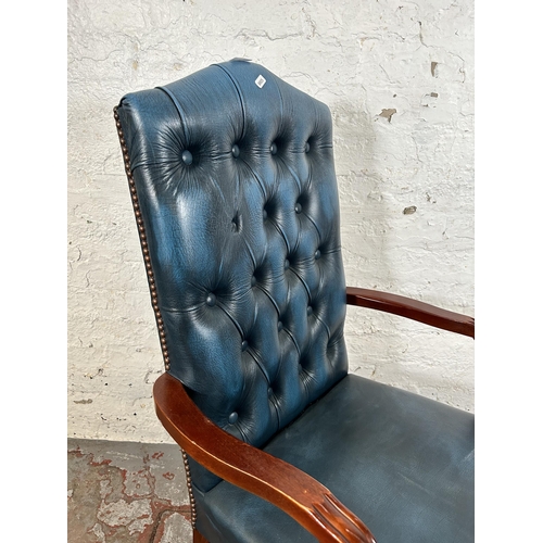 53 - A mahogany and blue leatherette Chesterfield office armchair