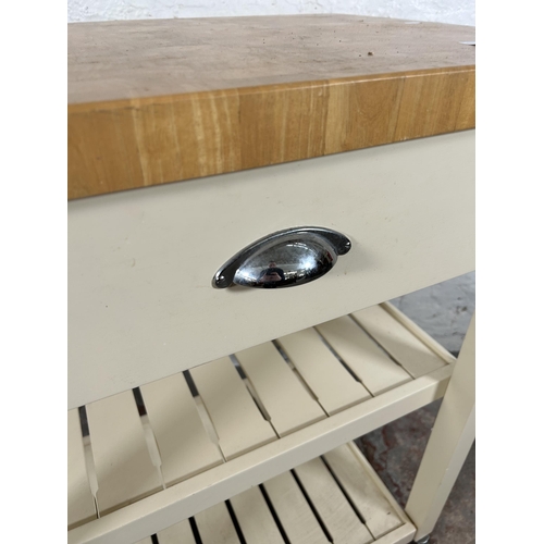 63 - A modern beech and white painted kitchen trolley island with single drawer and two shelves - approx.... 