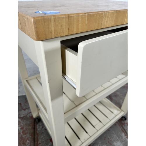 63 - A modern beech and white painted kitchen trolley island with single drawer and two shelves - approx.... 