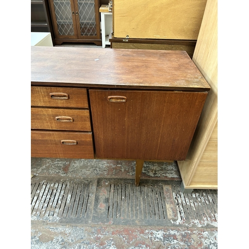 128 - A mid 20th century Nathan teak sideboard with three central drawers and two outer cupboard doors - a... 