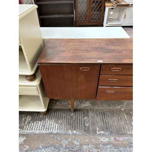 128 - A mid 20th century Nathan teak sideboard with three central drawers and two outer cupboard doors - a... 