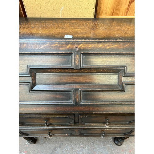 139 - A Jacobean style geometric carved oak bureau with two short drawers, one long drawer, fall front and... 