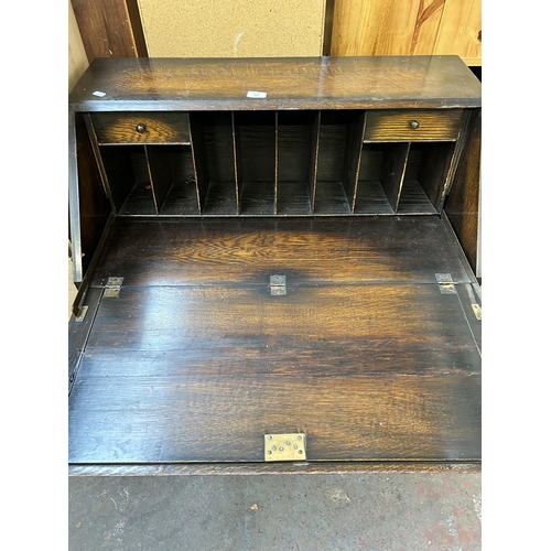 139 - A Jacobean style geometric carved oak bureau with two short drawers, one long drawer, fall front and... 