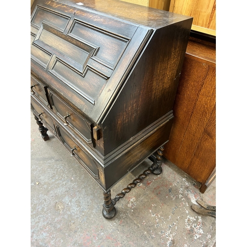 139 - A Jacobean style geometric carved oak bureau with two short drawers, one long drawer, fall front and... 