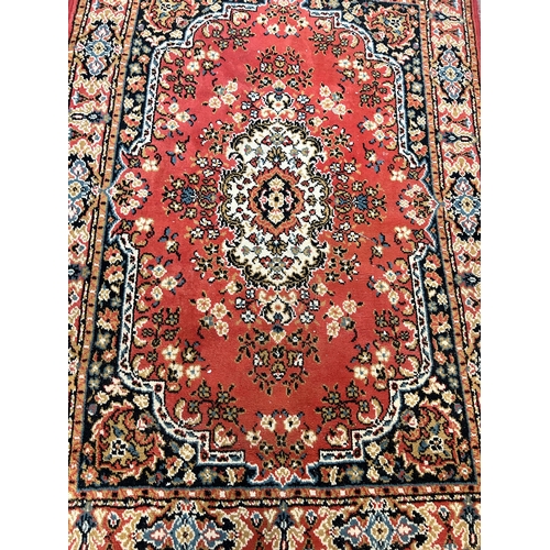 171 - A red floral patterned rug - approx. 176cm x 125cm