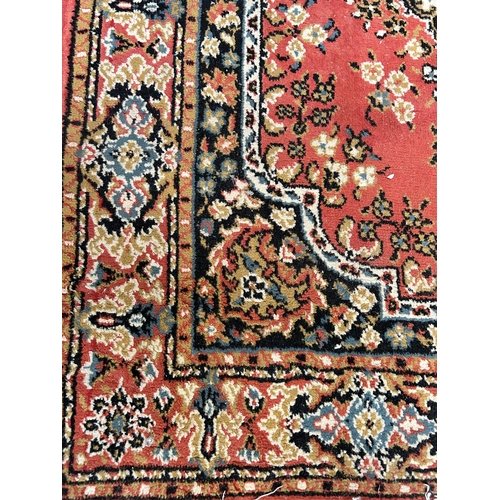 171 - A red floral patterned rug - approx. 176cm x 125cm