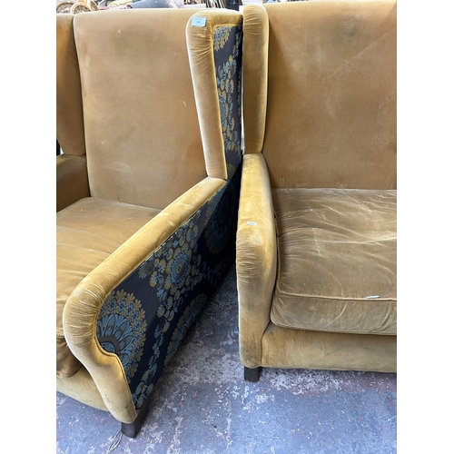 178 - A pair of mid 20th century yellow fabric upholstered wingback armchairs