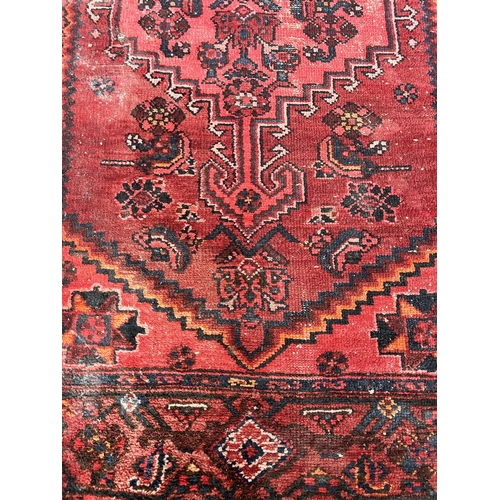 179 - A vintage red hand knotted rug - approx. 198cm long x 126cm wide