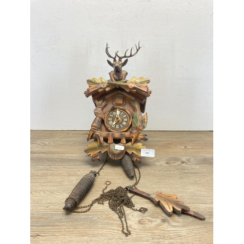 442 - A hardwood wall mountable cuckoo clock with two weights and pendulum - approx. 36cm high