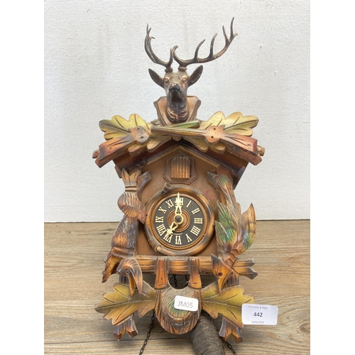 442 - A hardwood wall mountable cuckoo clock with two weights and pendulum - approx. 36cm high