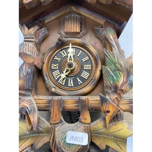 442 - A hardwood wall mountable cuckoo clock with two weights and pendulum - approx. 36cm high