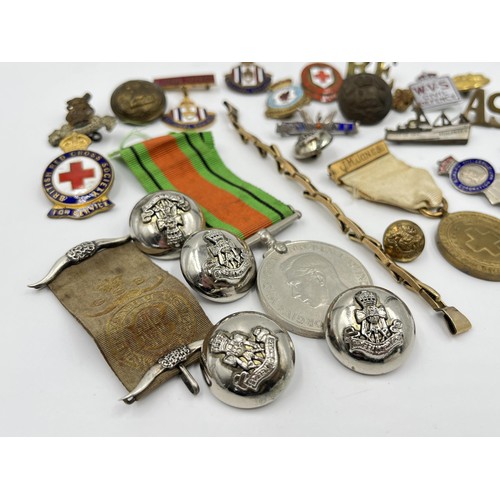 1360 - A collection of medals, badges and buttons to include WWII Defence medal, The British Red Cross Soci... 