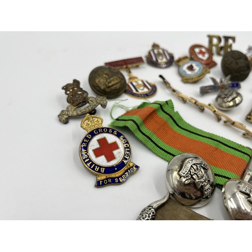 1360 - A collection of medals, badges and buttons to include WWII Defence medal, The British Red Cross Soci... 