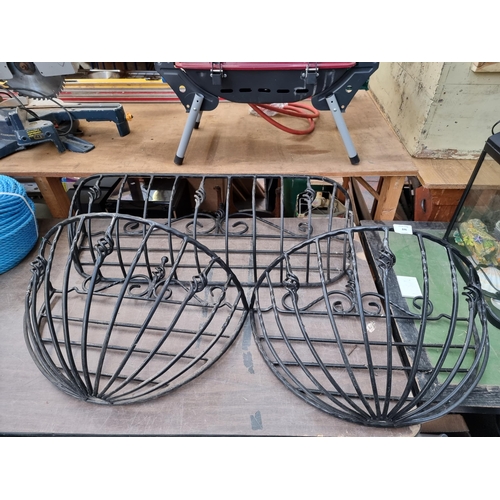 846 - Three Victorian style wrought iron wall hanging baskets - largest approx. 42cm high x 92cm wide