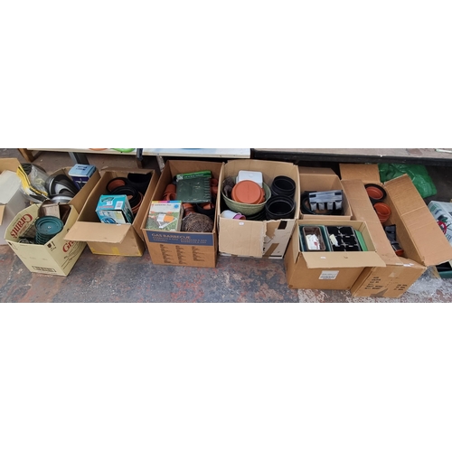 887 - Nine boxes containing garden items to include planters, bird box, hanging baskets etc.