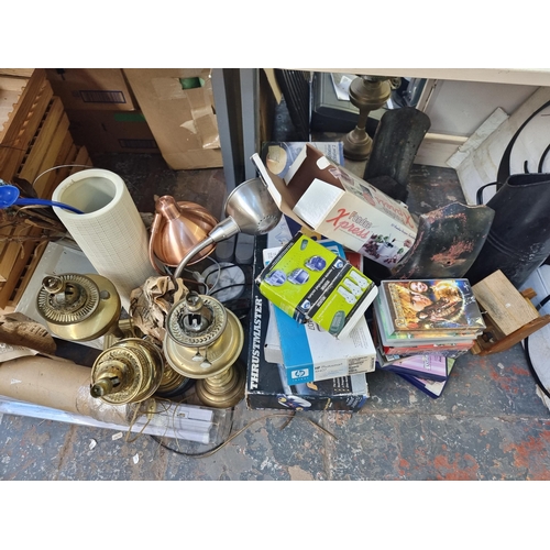 911 - A large collection of house clearance items to include brass oil lamps, step ladders, magazine rack,... 