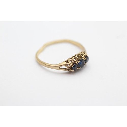 1077 - A 9ct gold sapphire three stone ring, size N½ - approx. gross weight 1.2 grams