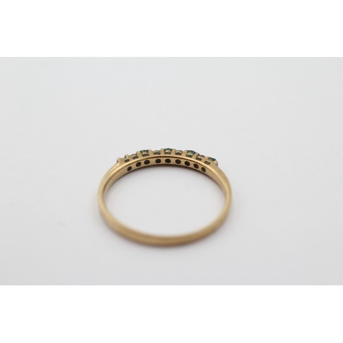 1099 - A 9ct gold diamond and green gemstone half eternity ring, size N - approx. gross weight 1 gram