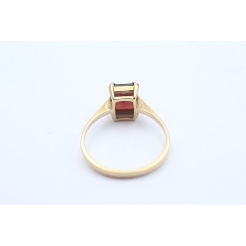 1102 - A 9ct gold baguette cut garnet solitaire ring, size N½ - approx. gross weight 1.8 grams