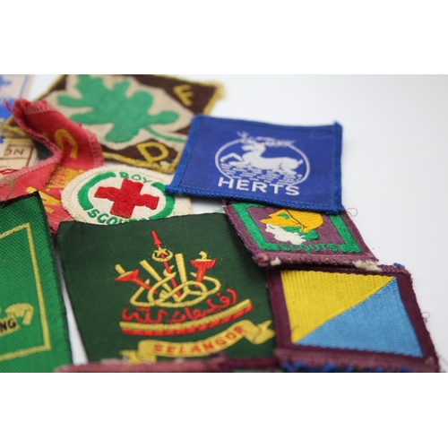 1354 - A collection of Boy Scouts badges, shoulder titles and patches to include Collins London stamped sil... 