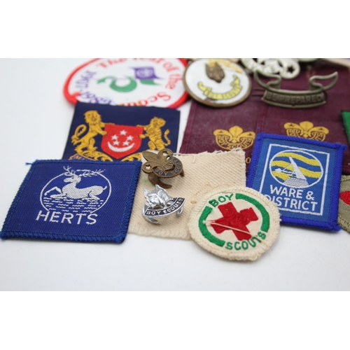 1354 - A collection of Boy Scouts badges, shoulder titles and patches to include Collins London stamped sil... 