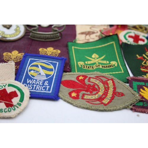 1354 - A collection of Boy Scouts badges, shoulder titles and patches to include Collins London stamped sil... 